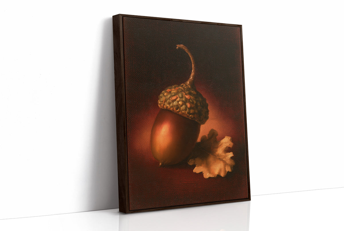A Single Acorn in Candlelight, one acorn resting beside a curled oak leaf on a dark brown ground, lit from one side and painted in chestnut, amber and deep shadow, as a framed canvas in a brown frame