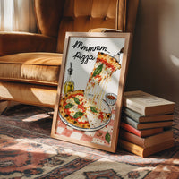 A Slice of Happiness Hangs Here, a slice of pizza lifting from a plate with a long strand of melted cheese, basil and tomato on top, the lettering Mmmmm in black script above and Pizza in red block letters below, in a wood frame on a rug beside a leather armchair and a stack of books