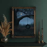 A Swing Left for the Moon, a bare tree with a dark tire swing hanging beneath a pale moon in a blue dusk field, painted in slate, midnight blue and moonlit cream, in an ornate gold frame on a deep green wall beside brass candlesticks