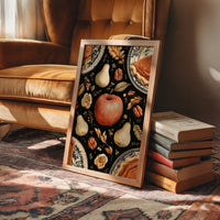 A Table Laid Before Dusk, a dark still life pattern of red apples, pale pears, walnuts and autumn leaves around pie plates, painted in charcoal, cream and rust, in a wood frame on a rug beside a leather armchair and a stack of books