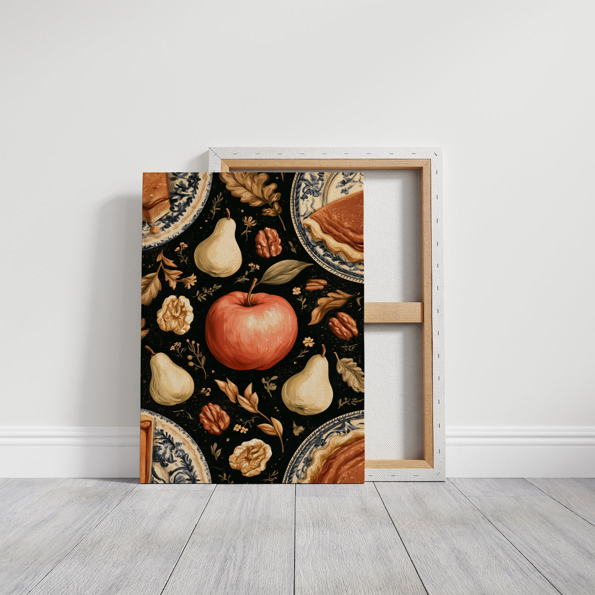 A Table Laid Before Dusk, a dark still life pattern of red apples, pale pears, walnuts and autumn leaves around pie plates, painted in charcoal, cream and rust, on a gallery canvas with wrapped edges leaning against a white wall