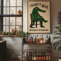 Bites Only With a Reason, a crocodile sitting upright in a plain wooden chair, in deep green on a cream ground, with a bold lettered line above reading I DON'T BITE and one below reading WITHOUT A REASON, in a wood frame on a brick wall above a bar cart of bottles and plants