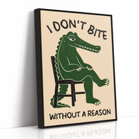 Bites Only With a Reason, a crocodile sitting upright in a plain wooden chair, in deep green on a cream ground, with a bold lettered line above reading I DON'T BITE and one below reading WITHOUT A REASON, as a framed canvas in a black frame