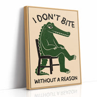 Bites Only With a Reason, a crocodile sitting upright in a plain wooden chair, in deep green on a cream ground, with a bold lettered line above reading I DON'T BITE and one below reading WITHOUT A REASON, as a framed canvas in a natural wood frame