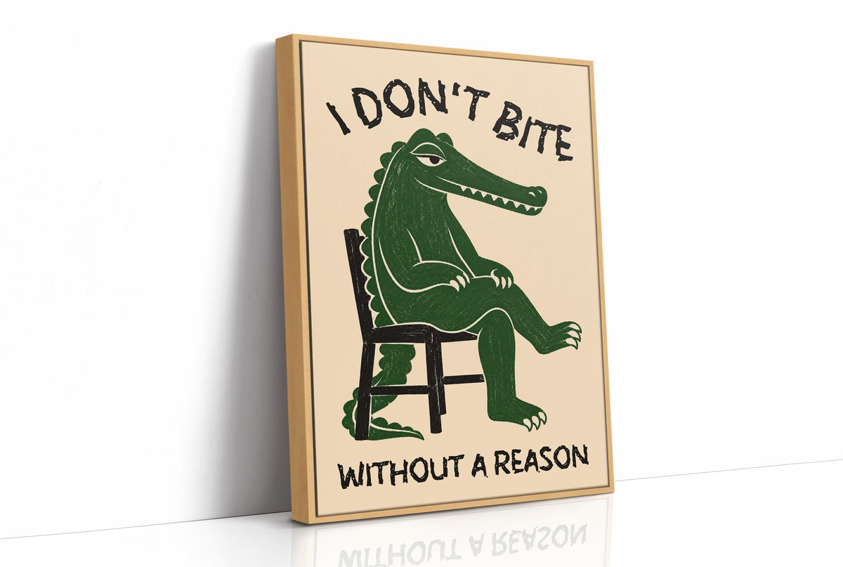 Bites Only With a Reason, a crocodile sitting upright in a plain wooden chair, in deep green on a cream ground, with a bold lettered line above reading I DON'T BITE and one below reading WITHOUT A REASON, as a framed canvas in a natural wood frame