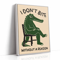 Bites Only With a Reason, a crocodile sitting upright in a plain wooden chair, in deep green on a cream ground, with a bold lettered line above reading I DON'T BITE and one below reading WITHOUT A REASON, as a framed canvas in a white frame