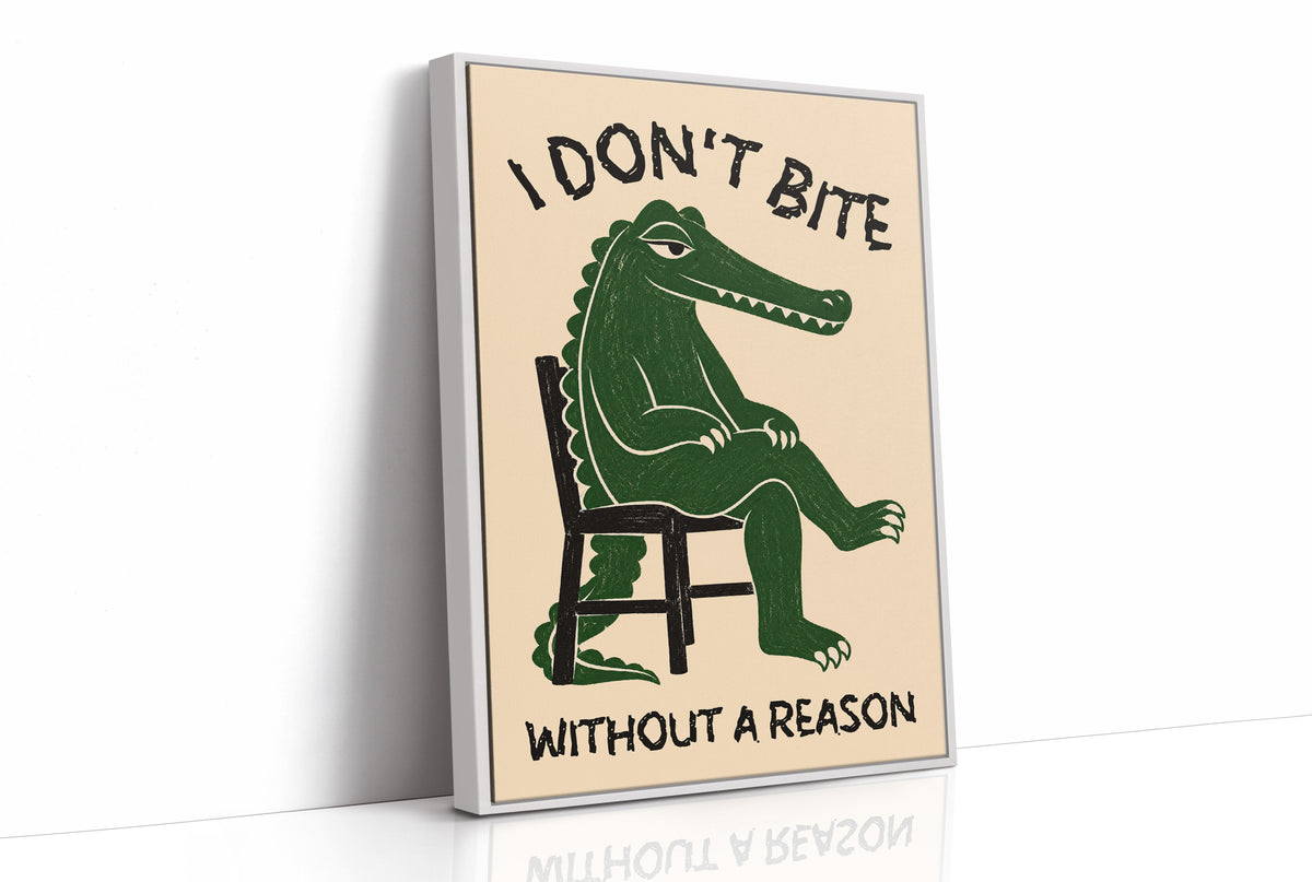 Bites Only With a Reason, a crocodile sitting upright in a plain wooden chair, in deep green on a cream ground, with a bold lettered line above reading I DON'T BITE and one below reading WITHOUT A REASON, as a framed canvas in a white frame