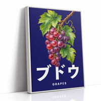 Clusters Heavy Over Midnight Water, a cluster of rose and purple grapes with green leaves hanging from a stem on a deep navy ground, with the Japanese katakana set in large white letters and the word GRAPES in small capitals beneath, as a framed canvas in a white frame