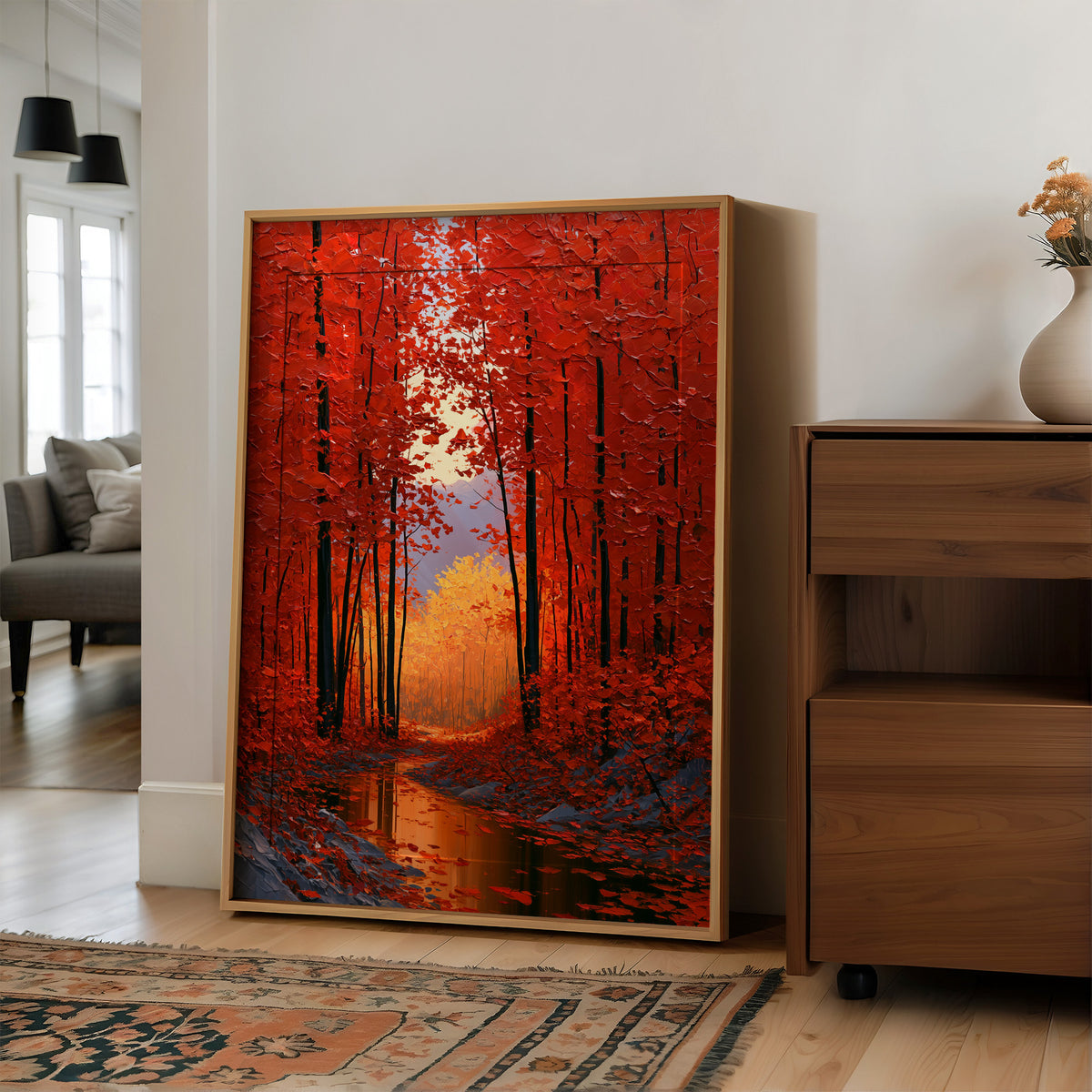 Crimson Hours Under the Canopy, a red autumn forest of tall dark trunks under crimson leaves, a pale sun glowing through the canopy above a stream of amber light, painted in ember red, deep umber and amber, in a wood frame on a wall beside a walnut cabinet and an open doorway