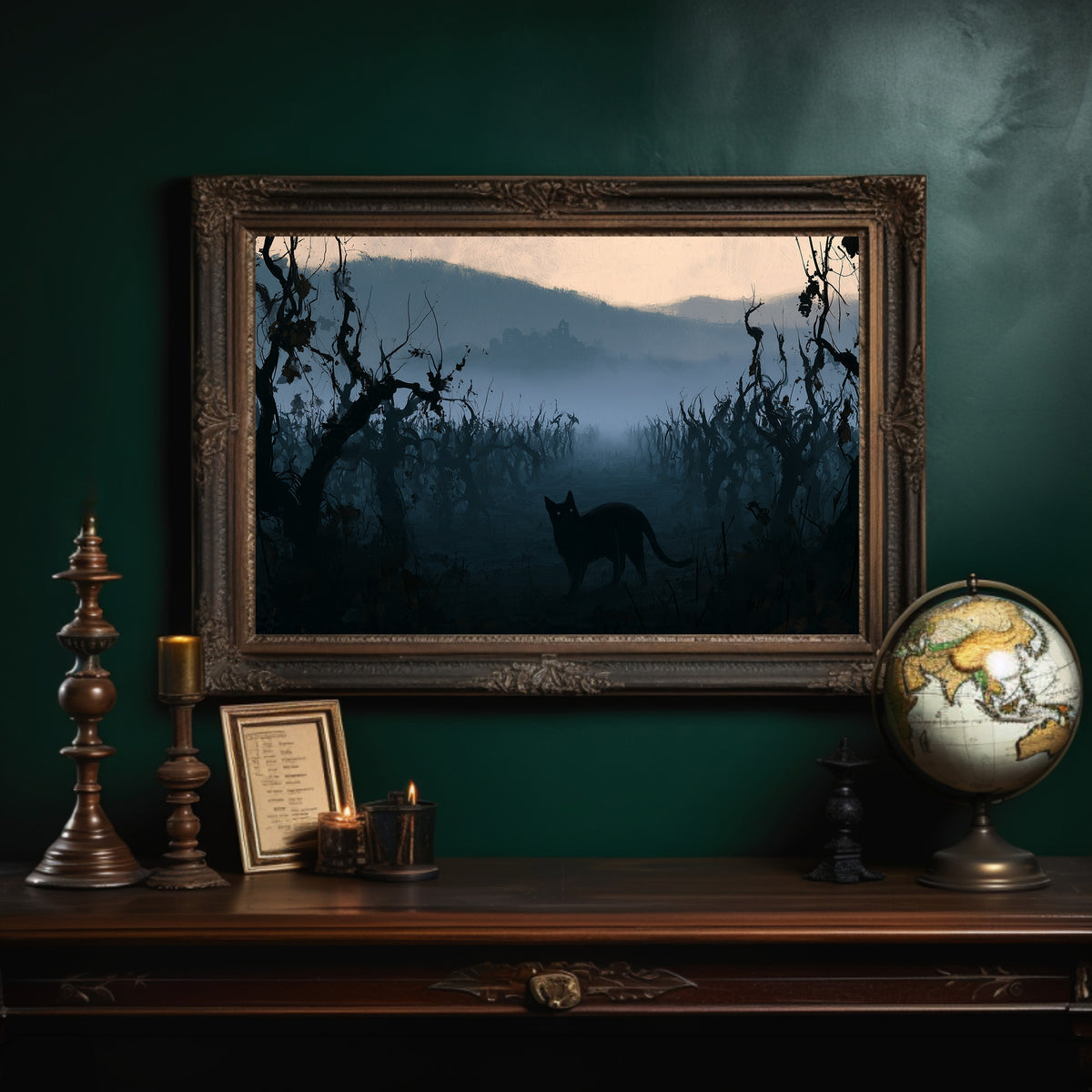 Dusk Keeps the Hollow Quiet, a black cat silhouette standing in misty hills under gnarled trees, peach sky band at dusk, blue and charcoal palette, in an ornate dark frame on a deep green wall above a mantel with a globe and candles