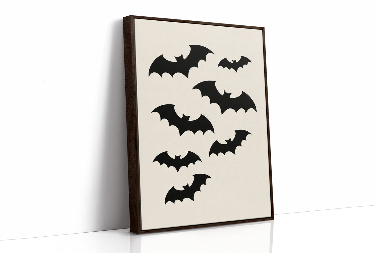 Evening Flight in Silhouette, a loose flock of black bat silhouettes spread across a cream ground in a simple, flat graphic arrangement, as a framed canvas in a brown frame