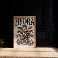 Every Head Grows Back Bolder, a many headed serpent with blue, red and gold scales rising in fans of heads, in a bold flash sheet style with a black lettered name across the top on a cream ground, in a dark frame on a black paneled wall above a sunlit herringbone floor