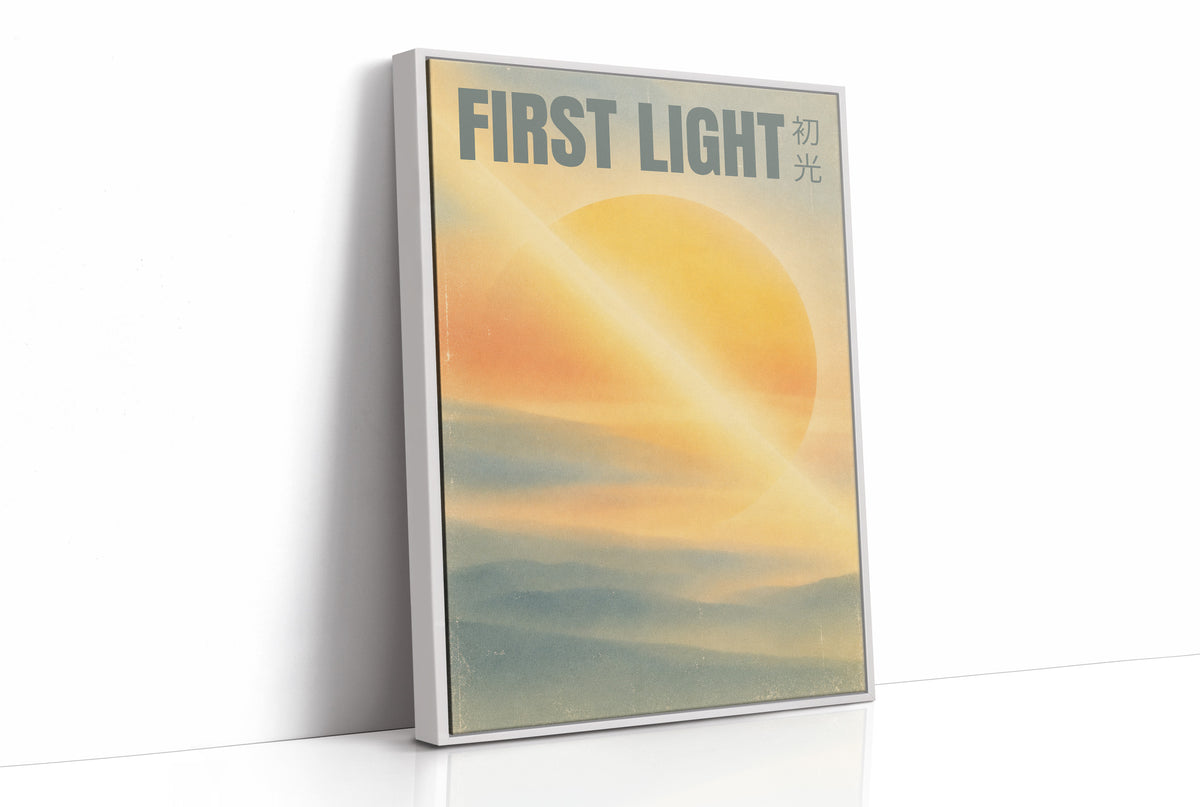 First Light Over a Quiet Sea, a pale sunrise over a soft sea, a warm yellow sun glowing above a band of blue water and peach clouds, with the words FIRST LIGHT in gray capitals across the top and a small Japanese word beside them, as a framed canvas in a white frame