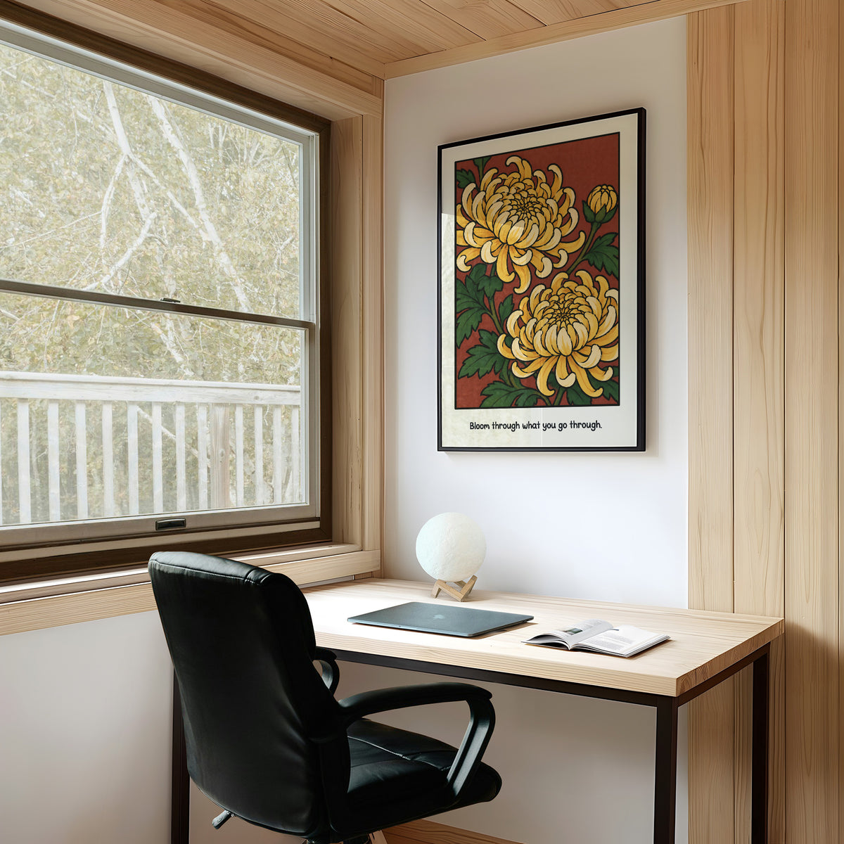 Gold Chrysanthemums Holding Their Ground, a cluster of yellow chrysanthemum blooms with green leaves and a bud on a rust red ground, with the words Bloom through what you go through in small black lettering along the bottom, on a study wall above a writing desk and a black desk chair
