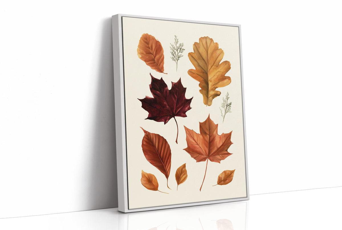 Gold Keeps Its Shape, a cluster of pressed autumn leaves in rust, maroon and gold on a cream ground, drawn in a botanical journal style, as a framed canvas in a white frame