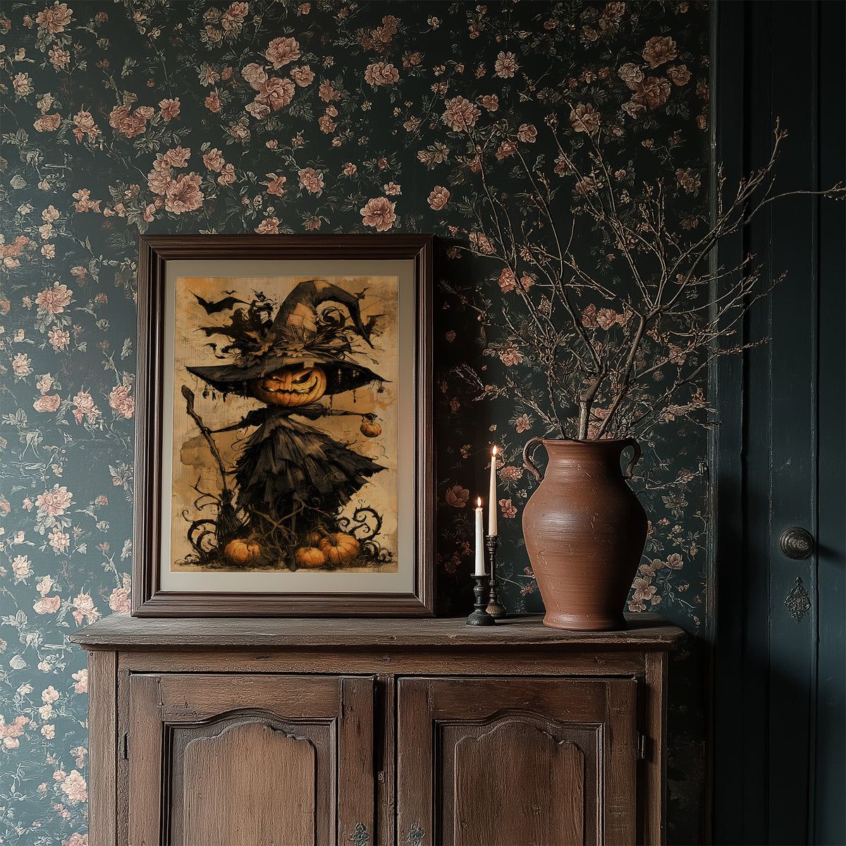 Her Lantern Face Keeps Watch, a witch in a tall pointed hat with a jack o lantern face, draped in a dark cloak with bats and curling vines, on a warm amber parchment ground, painted in ochre, charcoal and burnt orange, in a dark wood frame on a floral wallpaper wall above a rustic cabinet and a vase