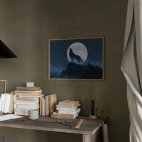 Howling at a Borrowed Moon, wolf howling from a rocky ledge under a full silver moon in deep blue night painting, in a thin wood frame on a moss green wall above a desk stacked with books