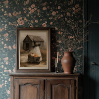 Just Passing Through, Boo, a ghost in a witch hat pushing a wheelbarrow of pumpkins past a weathered shed, painted in straw, gray and pale white, in a dark frame on a wooden dresser against floral wallpaper