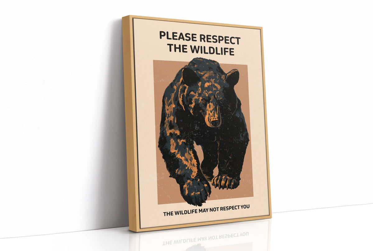 Keep a Respectful Distance, a large black bear with amber and brown fur, head low and shoulders bunched, set on a tan ground under bold black lettering that reads PLEASE RESPECT THE WILDLIFE in a vintage warning sign style, as a framed canvas in a natural wood frame
