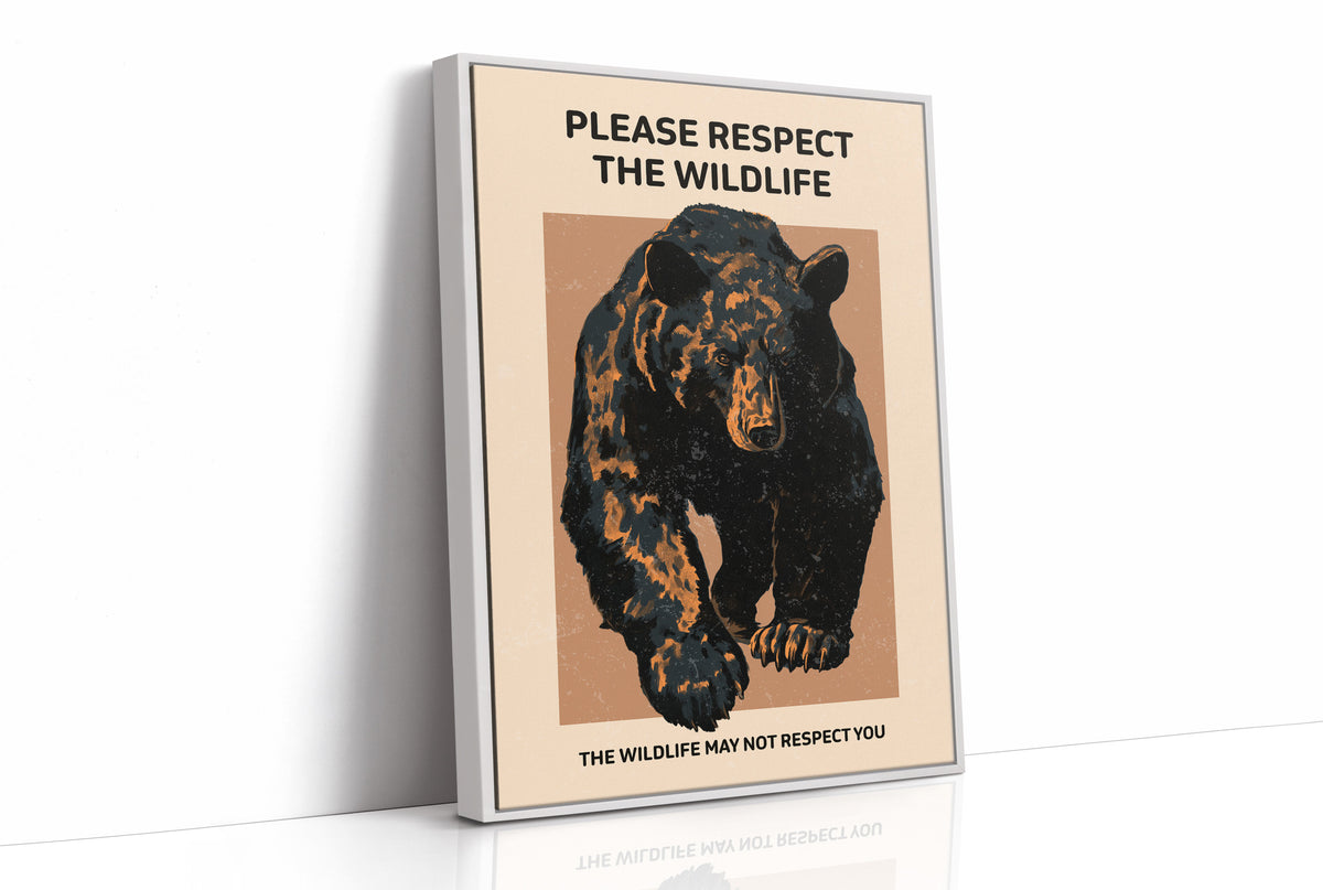 Keep a Respectful Distance, a large black bear with amber and brown fur, head low and shoulders bunched, set on a tan ground under bold black lettering that reads PLEASE RESPECT THE WILDLIFE in a vintage warning sign style, as a framed canvas in a white frame