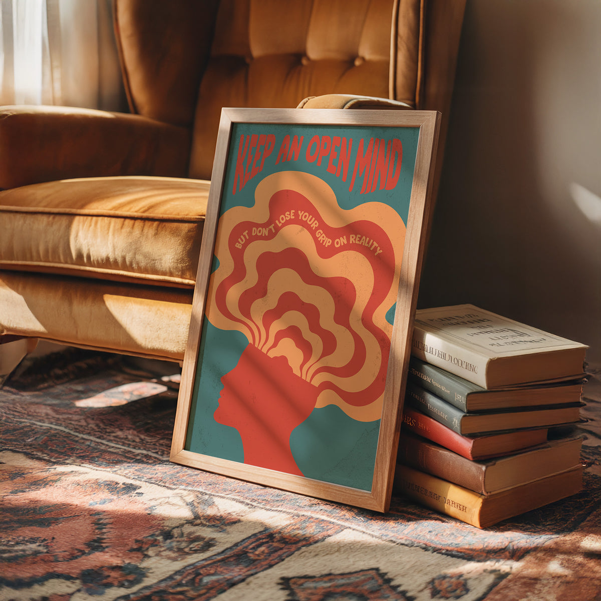 Keep an Open Mind Anyway, a psychedelic head in profile with concentric rings of orange, cream and red rising out of the crown, on a teal ground, with the words KEEP AN OPEN MIND in red lettering across the top and a small line, BUT DON'T LOSE YOUR GRIP ON REALITY, curved around the rings, in a wood frame on a rug beside a leather armchair and a stack of books