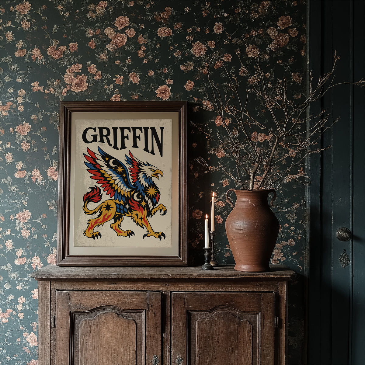 Keeper of the Gilded Gate, a winged lion guardian with a golden body, red and blue feathers and a black lettered name across the top, in a bold flash sheet style on cream parchment, in a dark wood frame on a floral wallpaper wall above a rustic cabinet and a vase