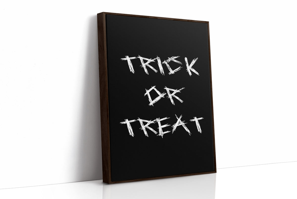 Knock Once for the Sweets, bold chalky white lettering reading TRICK OR TREAT on a solid black ground, hand lettered with a worn brush texture, as a framed canvas in a brown frame