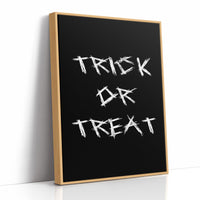 Knock Once for the Sweets, bold chalky white lettering reading TRICK OR TREAT on a solid black ground, hand lettered with a worn brush texture, as a framed canvas in a natural wood frame