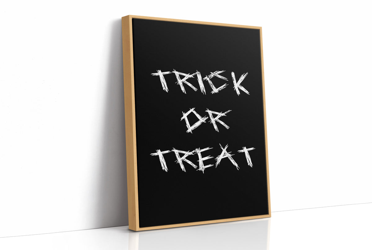 Knock Once for the Sweets, bold chalky white lettering reading TRICK OR TREAT on a solid black ground, hand lettered with a worn brush texture, as a framed canvas in a natural wood frame