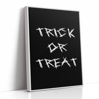 Knock Once for the Sweets, bold chalky white lettering reading TRICK OR TREAT on a solid black ground, hand lettered with a worn brush texture, as a framed canvas in a white frame