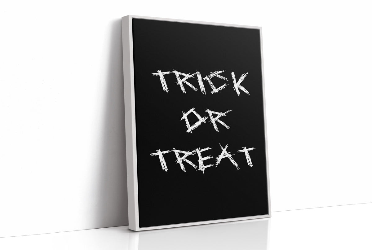 Knock Once for the Sweets, bold chalky white lettering reading TRICK OR TREAT on a solid black ground, hand lettered with a worn brush texture, as a framed canvas in a white frame