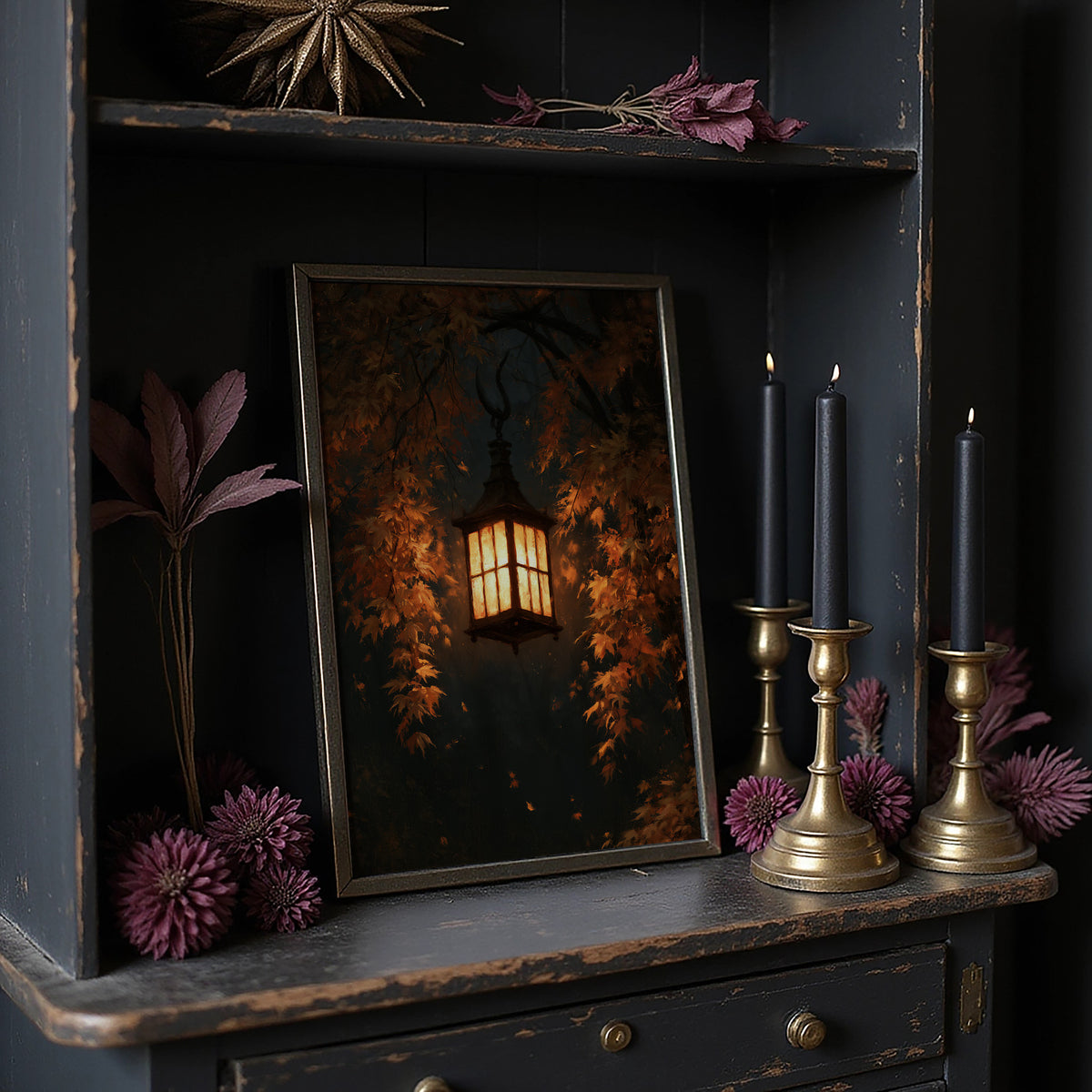 Left On for Someone, a glowing iron lantern hanging in a dark thicket of rust and amber leaves, painted in deep brown, ember orange and warm gold, in a dark frame on a black shelf beside brass candles and dried leaves