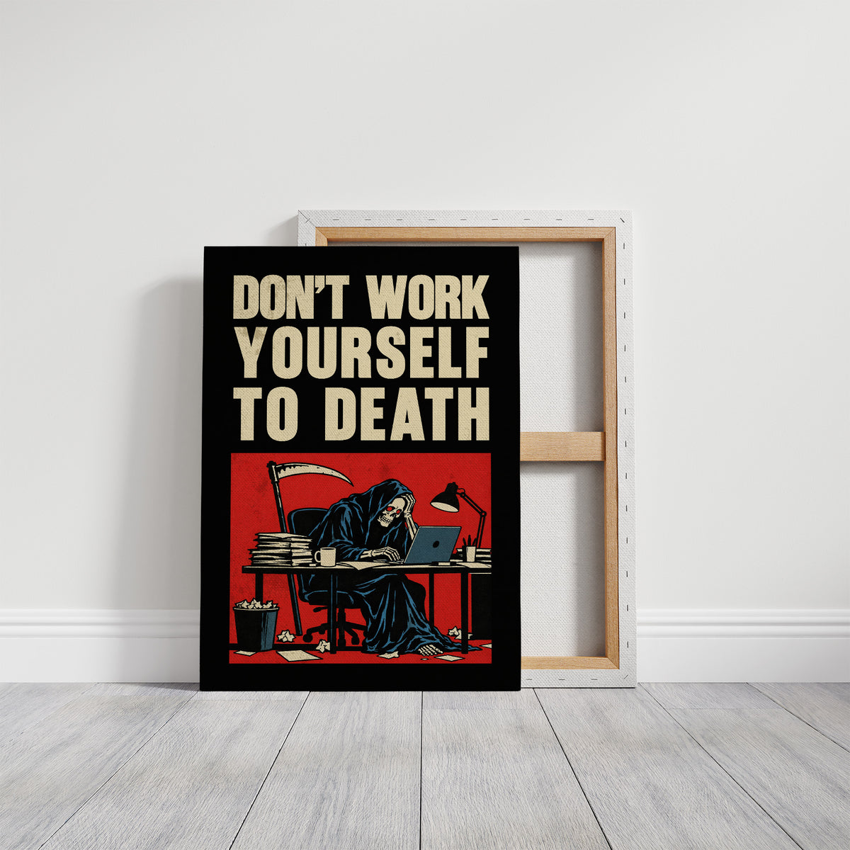 Let the Inbox Wait Till Monday, a hooded reaper hunched over a cluttered desk with a laptop and a stack of files, in a red panel with the lettering DON'T WORK YOURSELF TO DEATH in heavy cream capitals on black, on a gallery canvas with wrapped edges leaning against a white wall