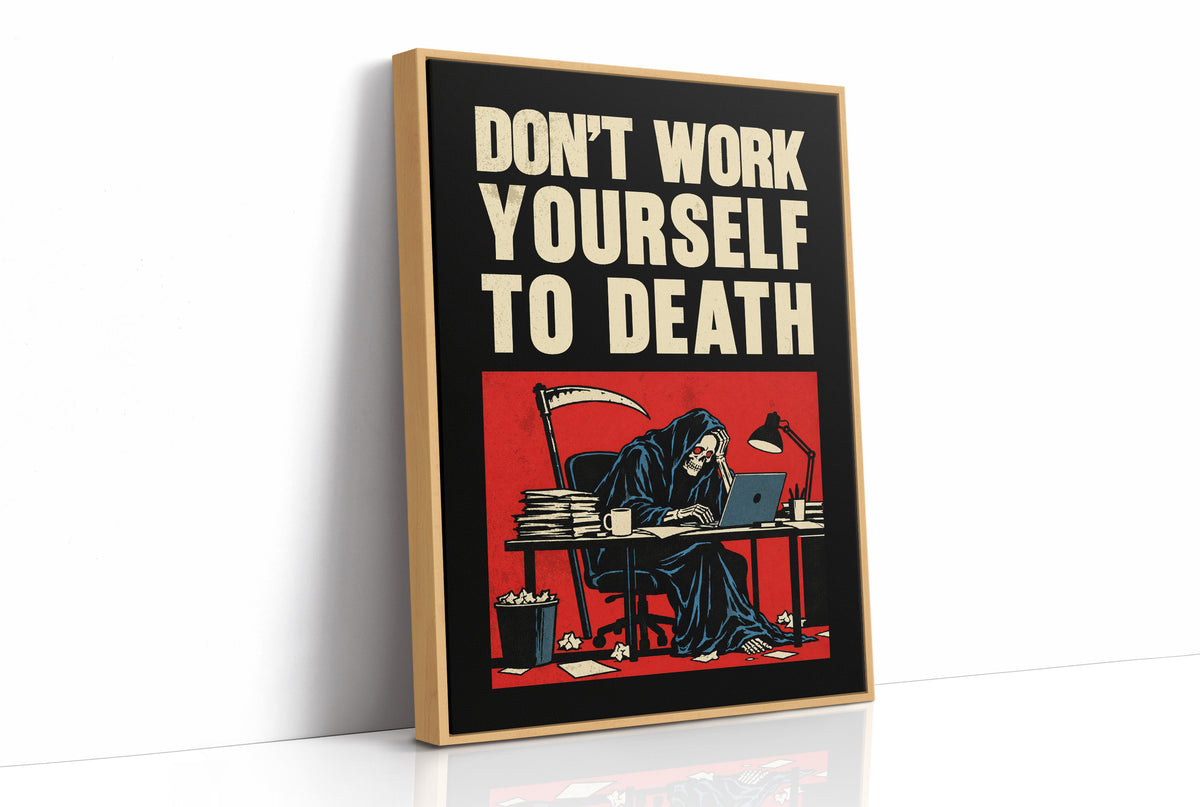 Let the Inbox Wait Till Monday, a hooded reaper hunched over a cluttered desk with a laptop and a stack of files, in a red panel with the lettering DON'T WORK YOURSELF TO DEATH in heavy cream capitals on black, as a framed canvas in a natural wood frame