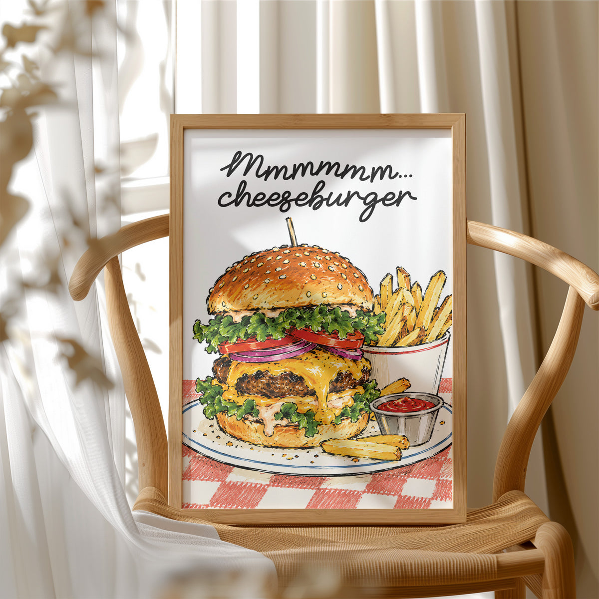 Mmmm Cheeseburger Makes Everything Better, a stacked cheeseburger with lettuce, tomato, cheese and a sesame bun beside fries and ketchup cups on a red and white checkered plate, with the lettering Mmmmm cheeseburger in black script across the top, in a wood frame beside a wicker chair by a sunny window
