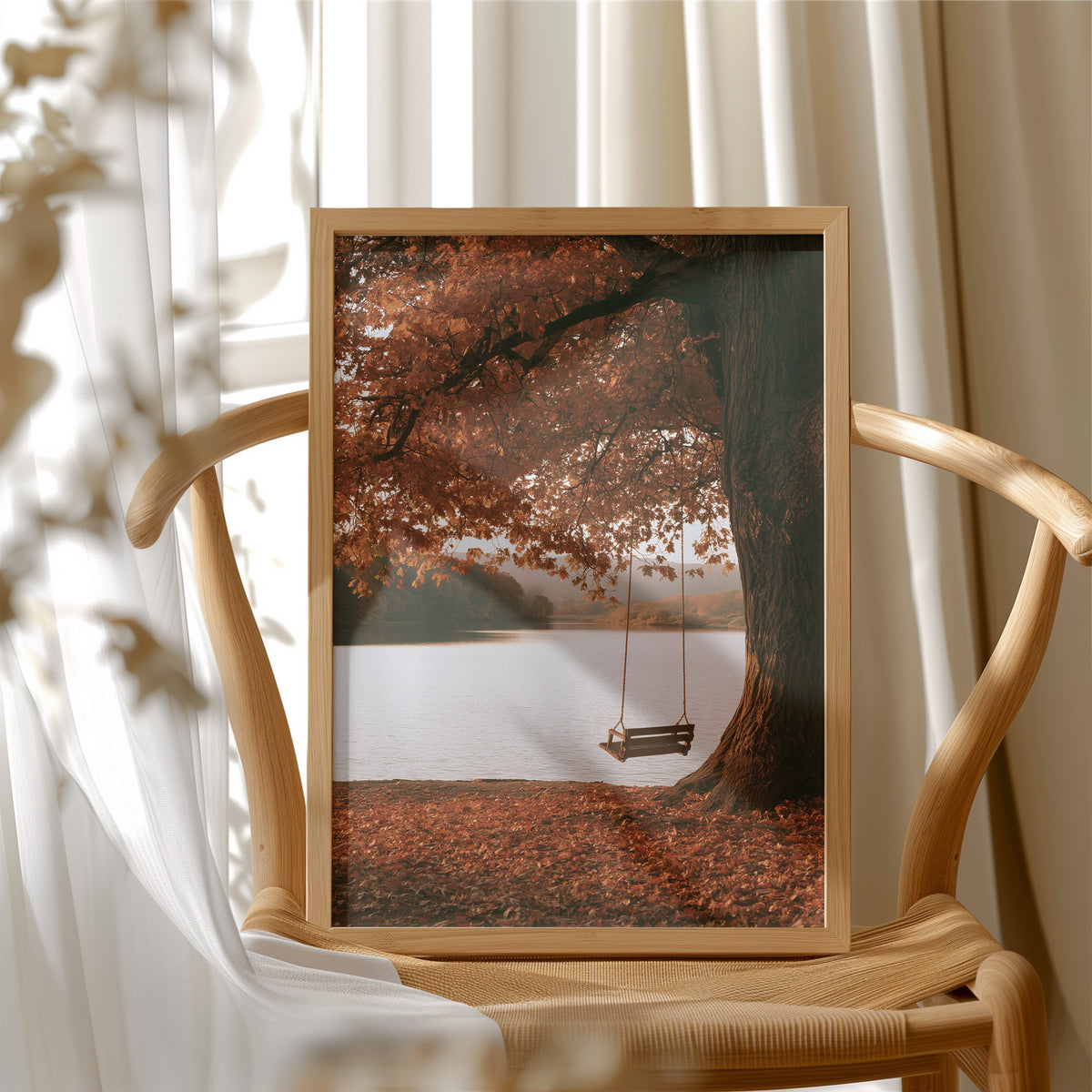 Nobody Has Swung Since Morning, a lone wooden swing hanging from a great tree with orange leaves above a still lake, painted in burnt orange, rust and misty gray, in a wood frame beside a wicker chair by a sunny window