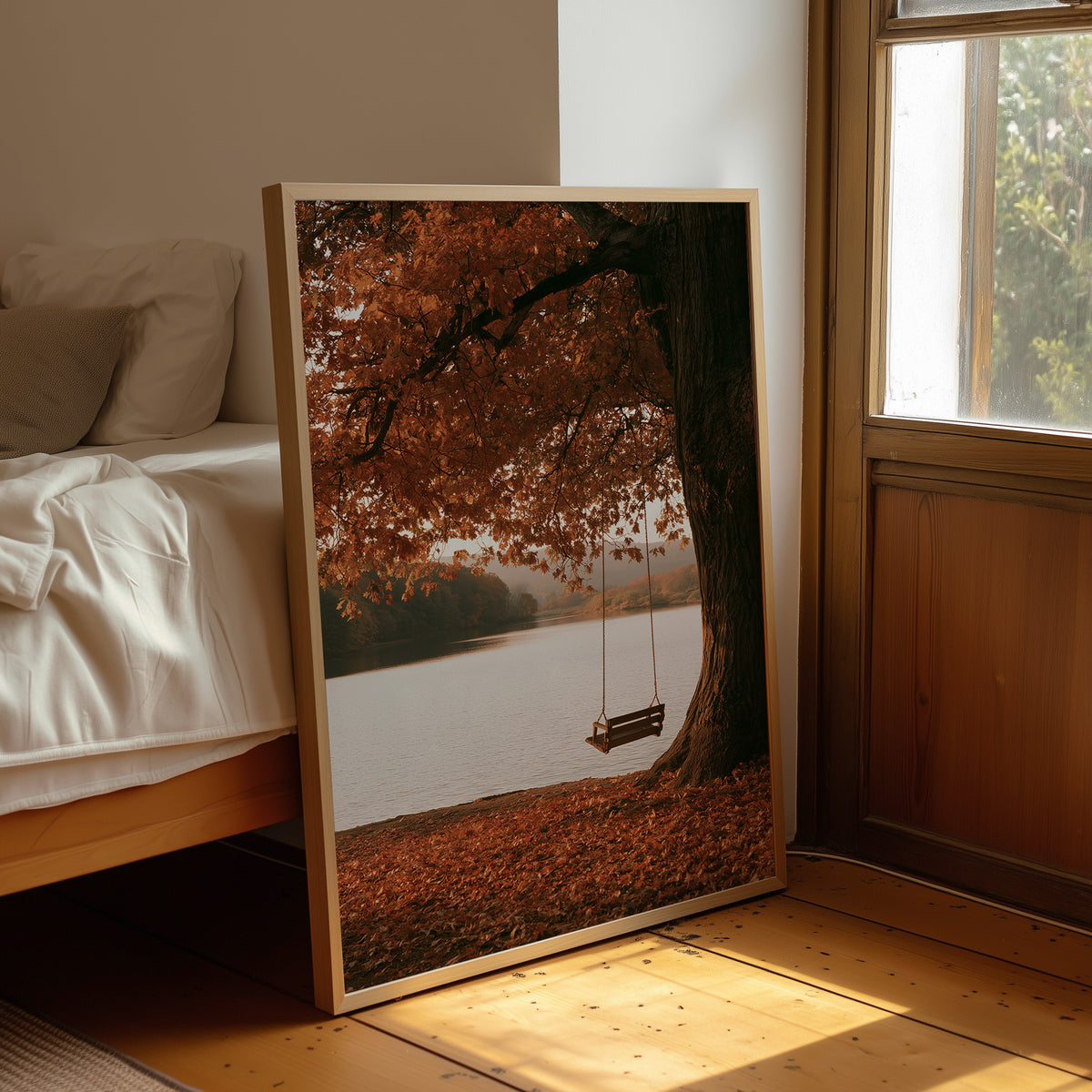 Nobody Has Swung Since Morning, a lone wooden swing hanging from a great tree with orange leaves above a still lake, painted in burnt orange, rust and misty gray, leaning on a wood floor in a bedroom beside white linen bedding