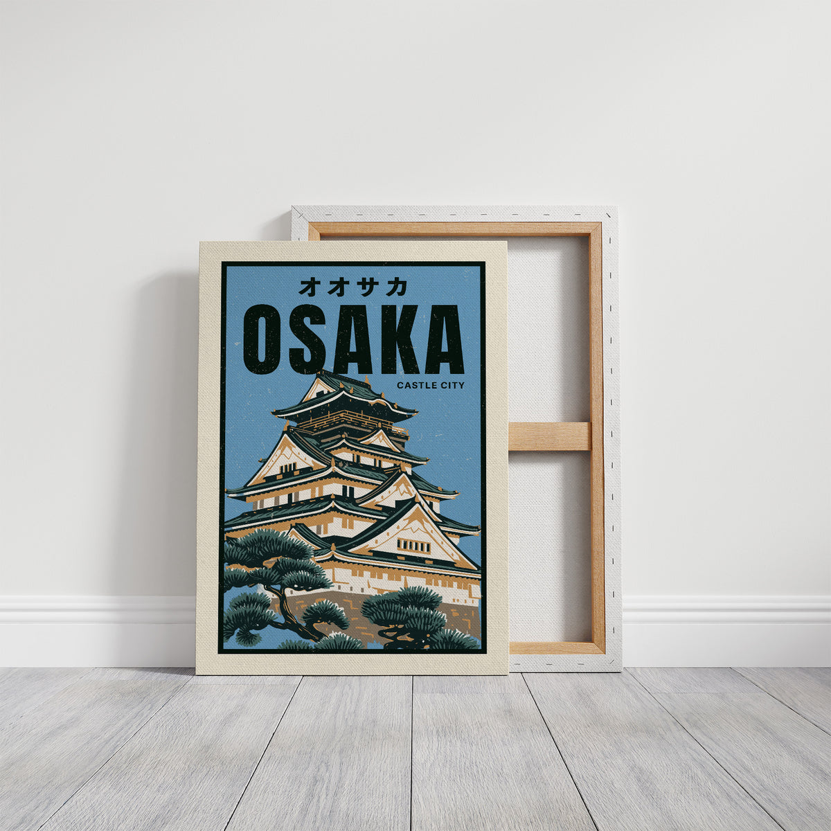 Osaka Castle Above the Evening Glow, a Japanese castle with tiered black roofs and white walls rising above green pines, in a flat travel poster style on a pale blue ground, with the katakana above and the word OSAKA in bold black capitals and CASTLE CITY in small type below, on a gallery canvas with wrapped edges leaning against a white wall