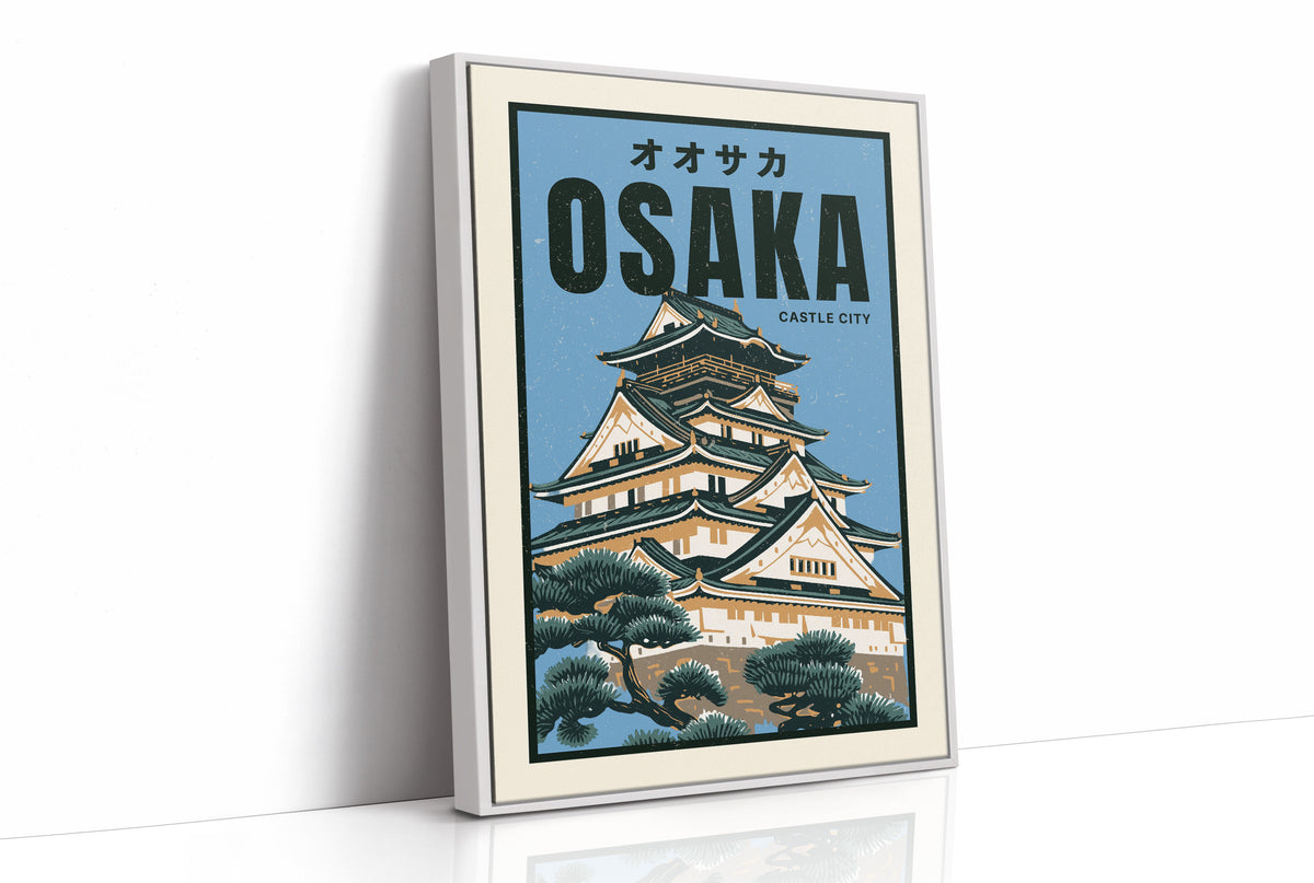 Osaka Castle Above the Evening Glow, a Japanese castle with tiered black roofs and white walls rising above green pines, in a flat travel poster style on a pale blue ground, with the katakana above and the word OSAKA in bold black capitals and CASTLE CITY in small type below, as a framed canvas in a white frame