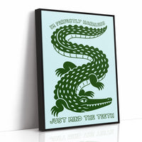 Perfectly Harmless, Mind the Teeth, a deep green crocodile curling down a pale mint ground, with a bold hand lettered line above reading I'M PERFECTLY HARMLESS and one below reading JUST MIND THE TEETH, as a framed canvas in a black frame