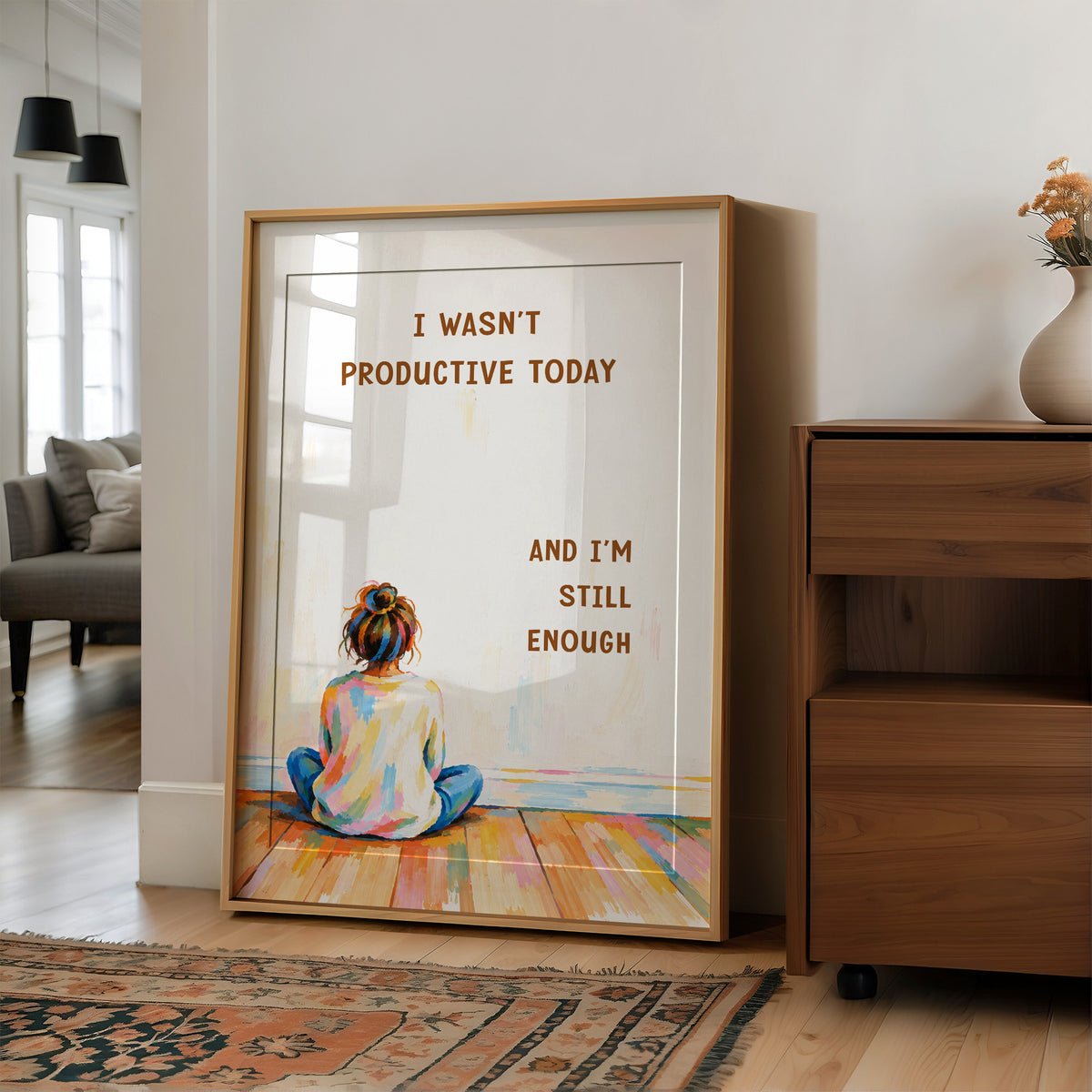 Quiet Hours on Painted Floors, a child seen from behind sitting cross legged on painted floorboards in coral, blue and cream, with two lines of bold brown lettering on a pale cream ground, in a soft illustrated style, in a wood frame on a wall beside a walnut cabinet and an open doorway