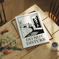 Quiet Hours Until Someone Knocks, a black ink woodcut style scene of a woman asleep in bed beside a lamp and a small framed plant picture while horned shadows lurk at the open door, and the words DO NOT DISTURB in black serif capitals on cream paper, in a dark frame on a black paneled wall above a sunlit herringbone floor