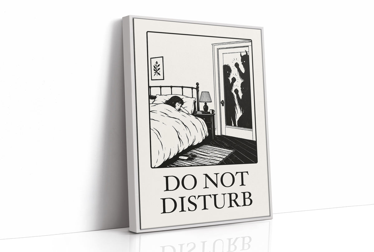 Quiet Hours Until Someone Knocks, a black ink woodcut style scene of a woman asleep in bed beside a lamp and a small framed plant picture while horned shadows lurk at the open door, and the words DO NOT DISTURB in black serif capitals on cream paper, as a framed canvas in a white frame
