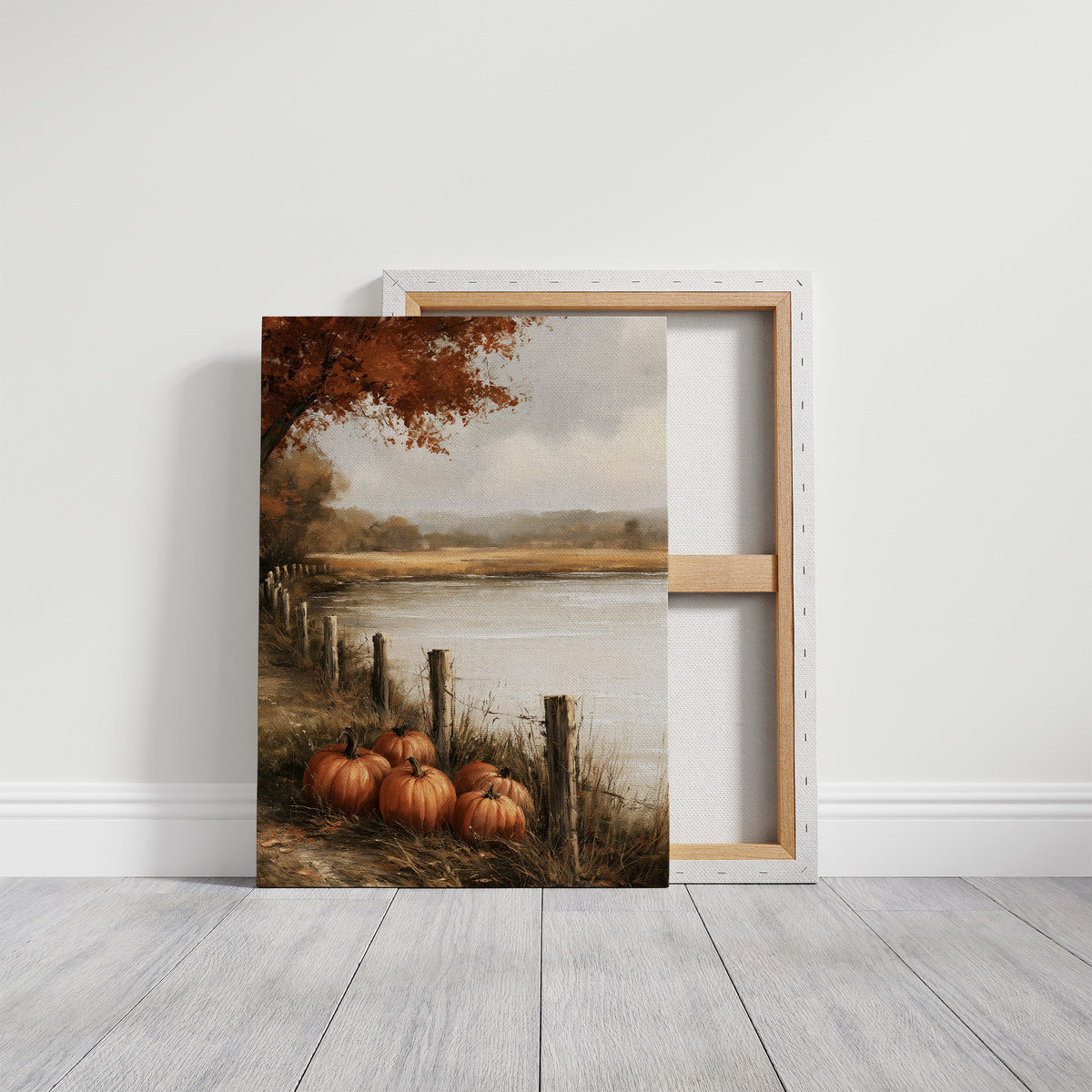 Quiet Water at the Fence Line, weathered fence posts and orange pumpkins on a grassy bank beside a misty lake, with a russet tree leaning over the water, painted in soft ochre, rust and pale gray, on a gallery canvas with wrapped edges leaning against a white wall