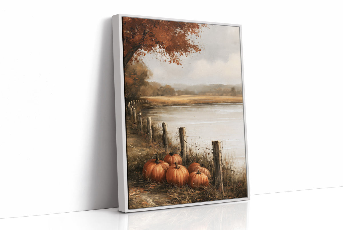 Quiet Water at the Fence Line, weathered fence posts and orange pumpkins on a grassy bank beside a misty lake, with a russet tree leaning over the water, painted in soft ochre, rust and pale gray, as a framed canvas in a white frame