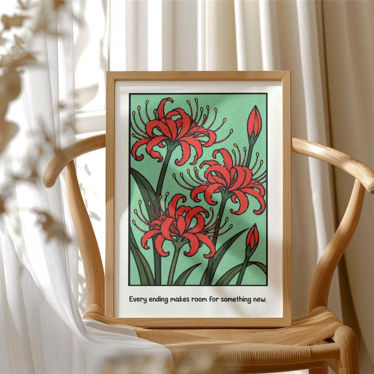 Red Lilies Make Room for Something New, red spider lily blooms with buds and dark green stems on a soft green ground, with the words Every ending makes room for something new in small black lettering along the bottom, in a wood frame beside a wicker chair by a sunny window