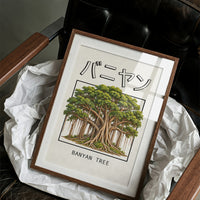 Roots That Remember the Ground, a banyan tree with a wide green canopy and many aerial roots hanging to the ground, drawn in a framed Japanese travel poster style with katakana above and BANYAN TREE below, in a wood frame on a black leather armchair beside crumpled white tissue