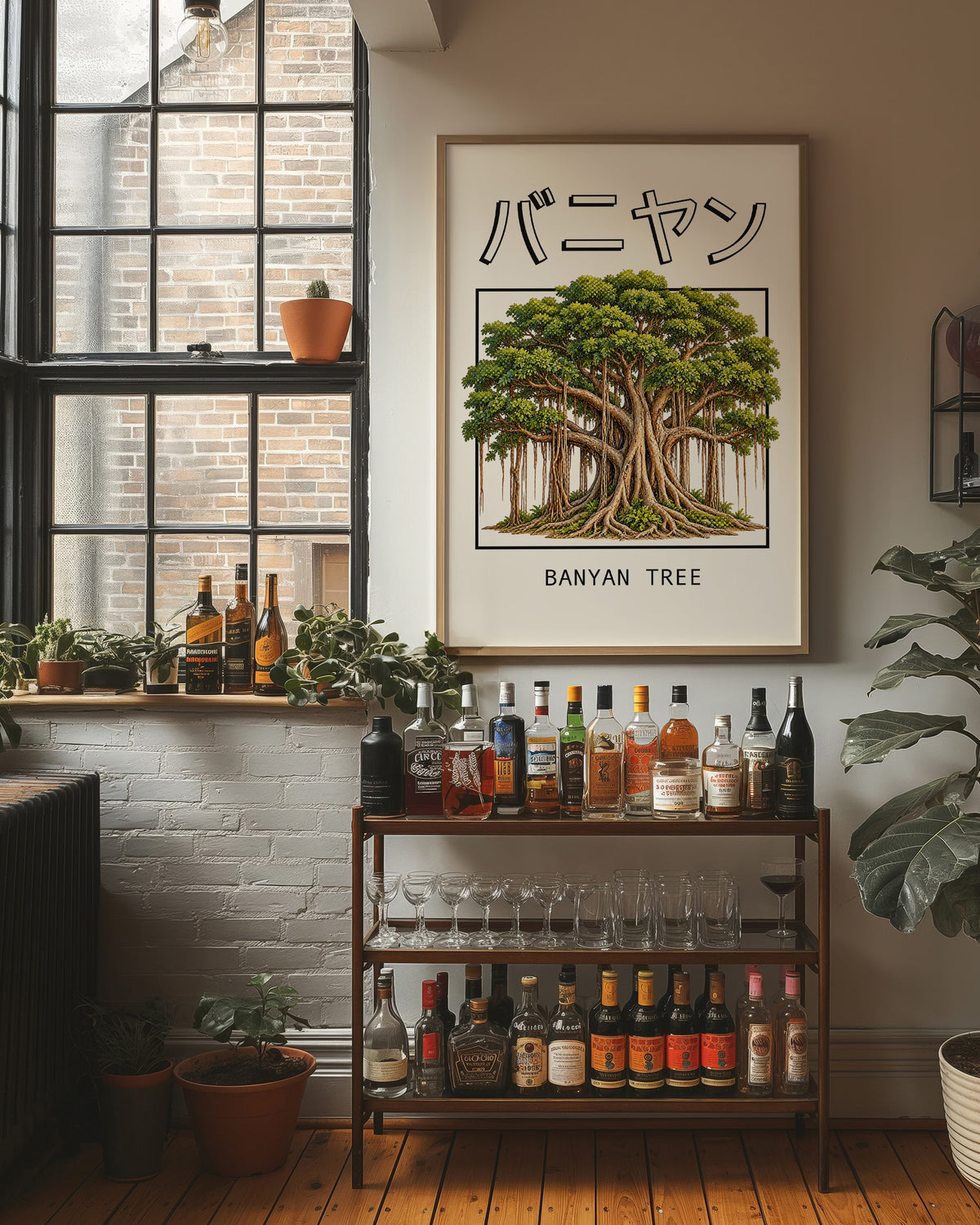 Roots That Remember the Ground, a banyan tree with a wide green canopy and many aerial roots hanging to the ground, drawn in a framed Japanese travel poster style with katakana above and BANYAN TREE below, in a wood frame on a brick wall above a bar cart of bottles and plants