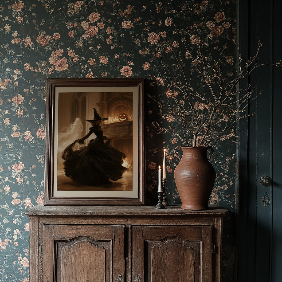 She Dances Past the Hearth Glow, a witch in a long black gown silhouetted before a glowing carved pumpkin in a stone hearth window, painted in umber, amber and shadow black, in a dark frame on a wooden dresser against floral wallpaper