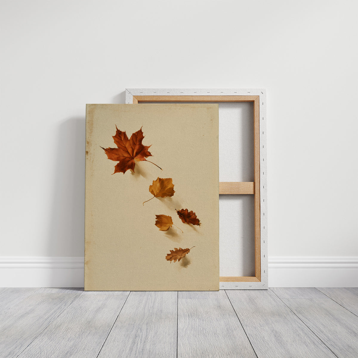 Slow Descent of the Maples, a trail of maple leaves in rust, amber and gold drifting diagonally across a warm beige ground, on a gallery canvas with wrapped edges leaning against a white wall